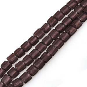 May include: A strand of brown glass beads with a metallic finish. The beads are square shaped and have a textured surface.