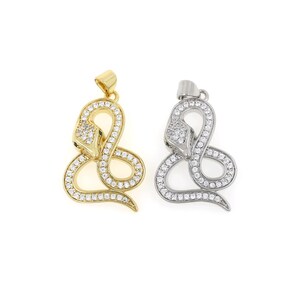 May include: Two gold and silver snake pendants with clear cubic zirconia stones. The snake is coiled and has a raised head.
