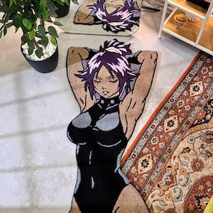 Peut inclure: Un tapis tufté en forme de personnage d'anime avec des cheveux violets attachés en queue de cheval haute. Le personnage porte un justaucorps noir et gris à col montant, les bras levés derrière la tête, les yeux fermés, teint bronzé.