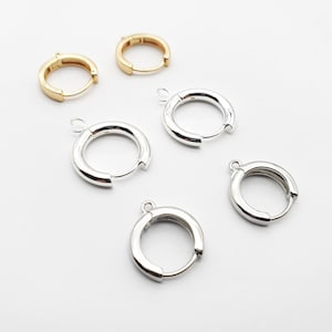 May include: Five pairs of hoop earrings, two gold and three silver, with a hinged clasp. The earrings are all the same size and shape.