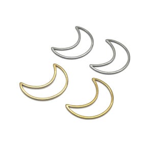 Peut inclure: Quatre breloques en forme de croissant de lune. Deux sont dorées et deux sont argentées. Les breloques sont en métal et ont un design simple et ouvert. Elles sont probablement utilisées pour la fabrication de bijoux ou d'autres travaux manuels.