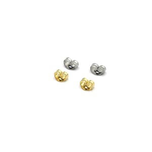 May include: Four earring backs, two in gold and two in silver, are displayed against a white background. The earring backs have a butterfly shape, designed to secure earrings. The gold backs have a shiny finish.