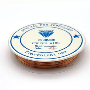 May include: A spool of copper wire with a white label featuring blue text that reads SPECIAL FOR JEWELLERY, a diamond icon, Chinese characters, COPPER WIRE, Size, Color 4, and Convenient use. The wire is metallic copper in color.
