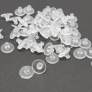 May include: A pile of clear plastic earring backs. The backs are designed to hold earrings in place and are commonly used with stud earrings.
