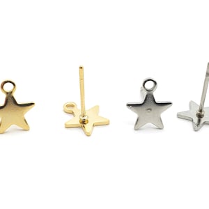 May include: Four star-shaped stud earrings. Two are gold-coloured, and two are silver-coloured. Each earring has a post for insertion into the ear and a small loop at the top of the star. The earrings are displayed on a white background.