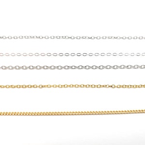 May include: Four different chain styles in silver and gold. The chains are laid out horizontally on a white background.