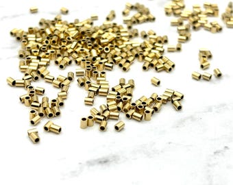 May include: A large quantity of gold-colored metal jump rings. The rings are small and cylindrical in shape.