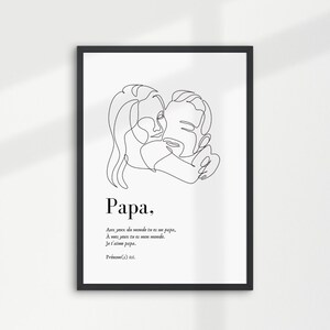 May include: Black and white line art print of a father and child hugging. The print has the word "Papa" and a quote in French below the image. The print is framed in a black frame and hanging on a white wall.