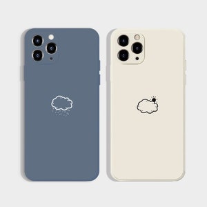 May include: Two phone cases with different designs. The left case is blue with a white cloud and raindrops. The right case is white with a black cloud and sun.
