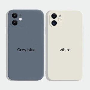 May include: Two silicone phone cases, one in grey blue and one in white. Both cases have a raised camera bump and the text "Grey blue" and "White" printed on them.