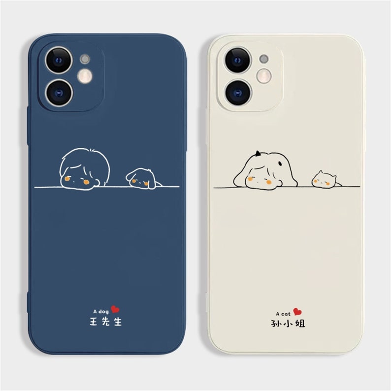 Peut inclure: Deux coques de t&eacute;l&eacute;phone, une bleu marine et une blanc cass&eacute;. La coque bleu marine pr&eacute;sente un dessin de chien de dessin anim&eacute; avec le texte "A dog" et des caract&egrave;res chinois. La coque blanc cass&eacute; a un design de chat avec le texte "A cat" et des caract&egrave;res chinois.