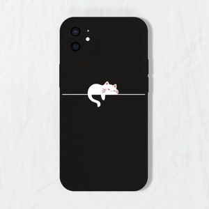 May include: Black phone case with a white cat illustration sleeping on a line. The phone case has a camera lens cutout.
