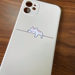 May include: White phone case with a cartoon cat design and the text "@AiQ" on the bottom.