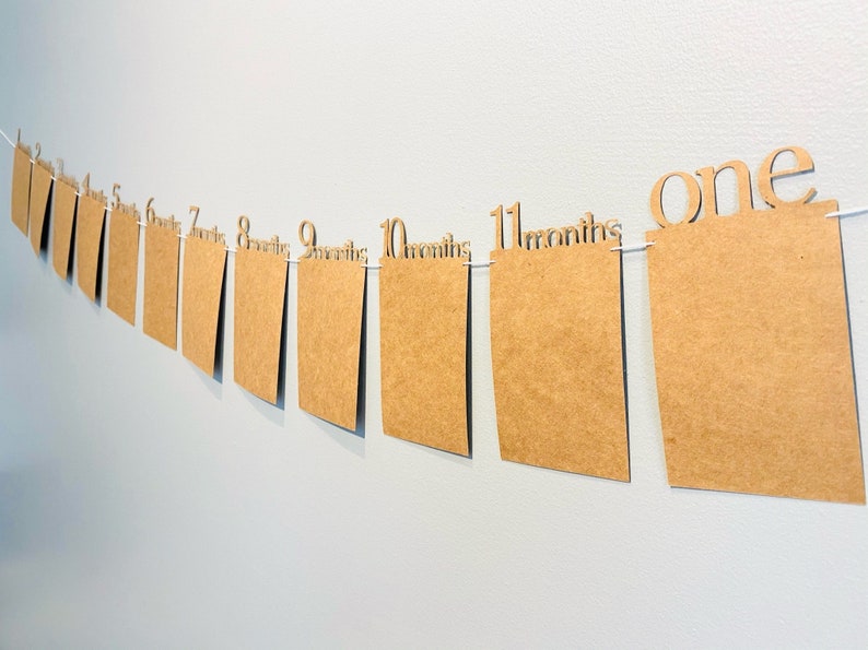 May include: A brown paper banner with the numbers 1 through 11 and the word "months" printed on each. The banner also includes the word "one" at the end.