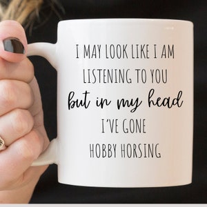 May include: White ceramic mug with black text that reads "I may look like I am listening to you but in my head I've gone hobby horsing."