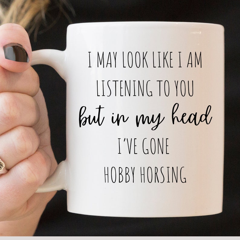 May include: White ceramic mug with black text that reads "I may look like I am listening to you but in my head I've gone hobby horsing."