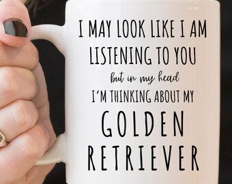May include: White ceramic coffee mug with black text that reads "I may look like I am listening to you but in my head I'm thinking about my Golden Retriever".