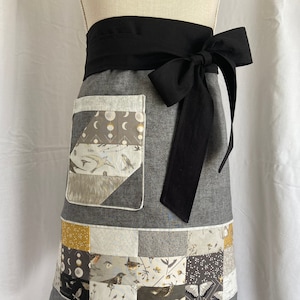 Half apron with nature-themed cotton patchwork detail.