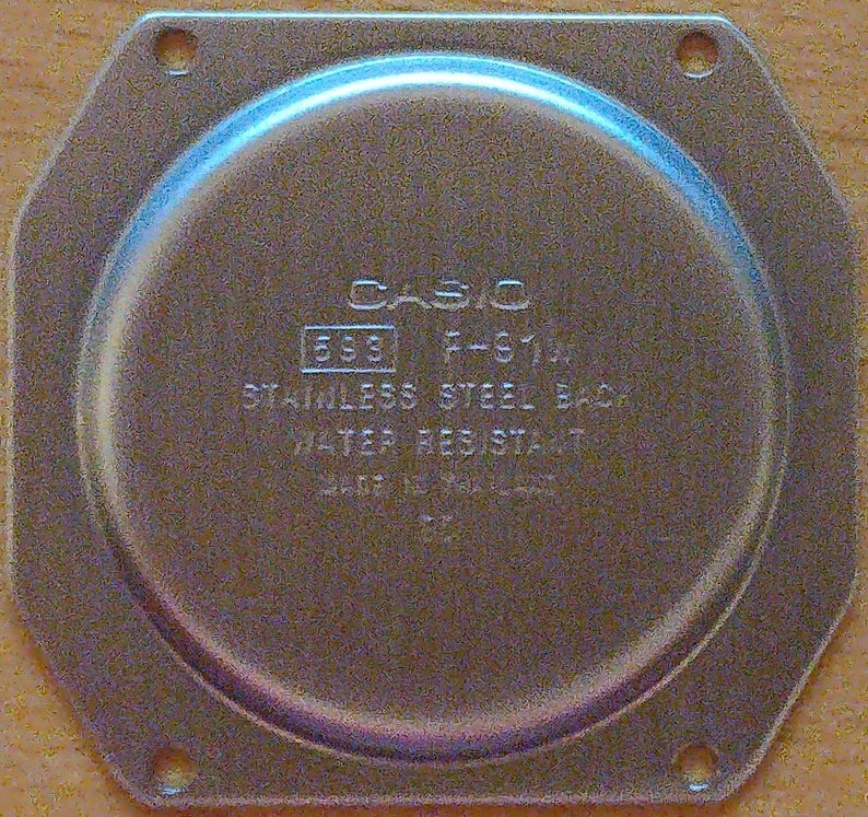 May include: A silver watch back with the text 'CASIO F-S10F 533 STAINLESS STEEL BACK WATER RESISTANT' on it.