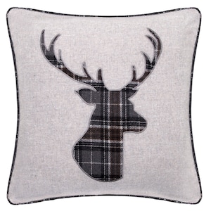 May include: A grey and white throw pillow with a black and brown tartan deer silhouette.