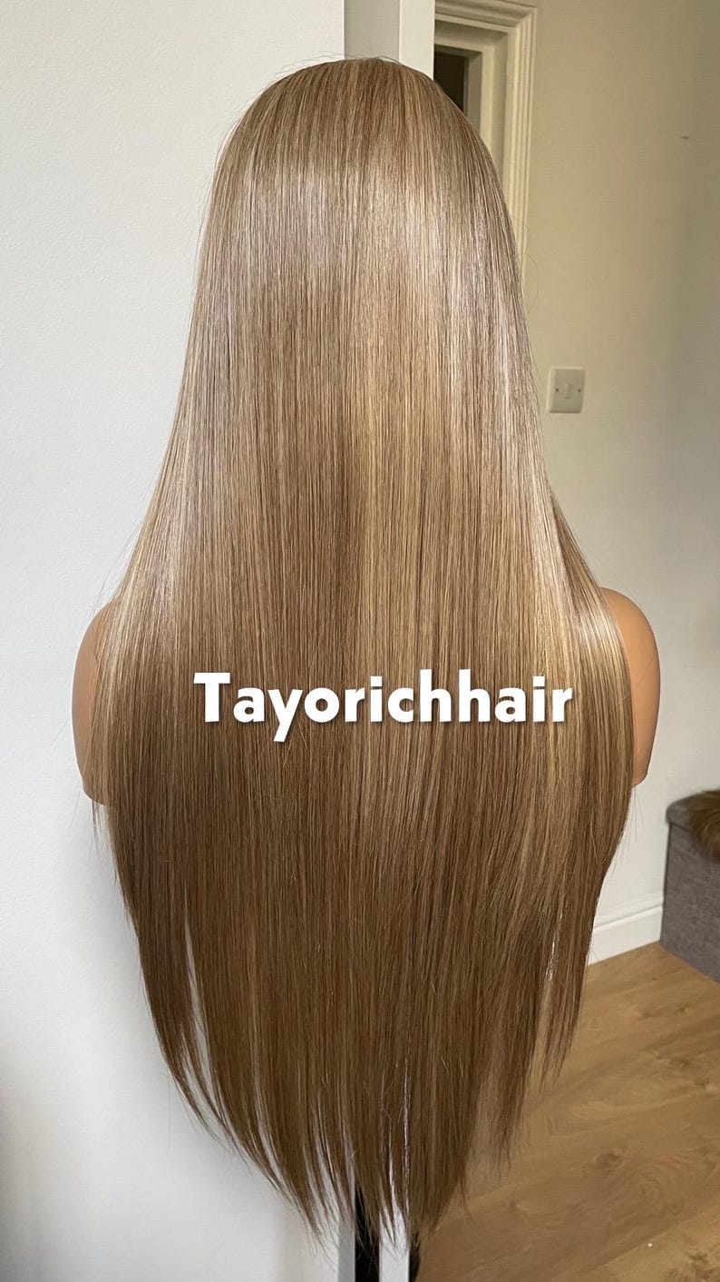 May include: A long, straight wig with a blend of blonde and light brown tones. The hair is styled to fall down the back. The text "Tayorichhair" is displayed across the front of the wig.