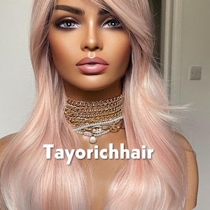 May include: A mannequin head displaying a long, layered wig with a blend of pink and light blonde tones. The wig features a side-swept bang and is styled with loose waves. The text "Tayorichhair" is visible on the image.