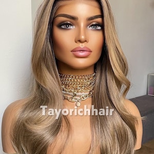 May include: A long, wavy wig featuring a dark root transition into a light brown and blonde balayage color palette. The hair is styled with a center part and soft waves. The text Tayorichhair is visible across the chest area of the mannequin.