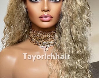 May include: A long, wavy, ash-blonde lace front wig on a mannequin head. The wig features a center part and layered, textured curls. The mannequin wears a layered gold-tone chain necklace. The text Tayorichhair is visible on the image.
