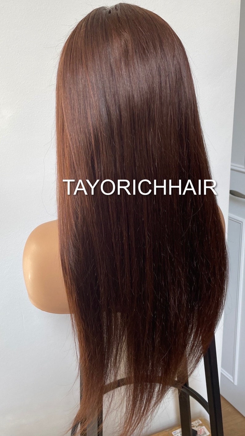 May include: A long, straight, brown human hair wig on a mannequin head. The wig is styled with a center part and falls to the shoulders. The wig is labeled "TAYORICHHAIR".