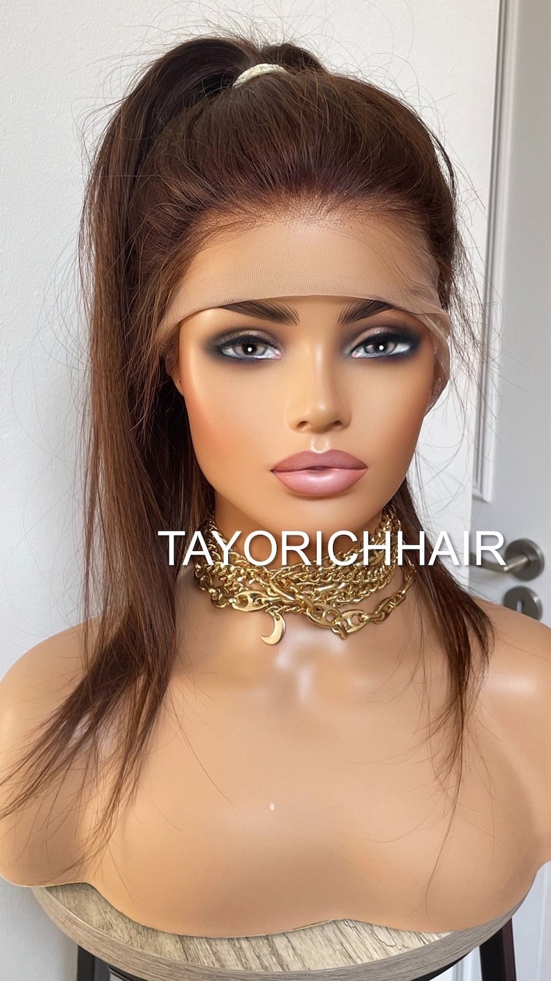 May include: A long, straight, brown human hair wig with a lace front. The wig is styled in a high ponytail. The wig is on a mannequin head. The mannequin is wearing a gold chain necklace with a crescent moon pendant. The text "TAYORICHHAIR" is visible on the mannequin's chest.