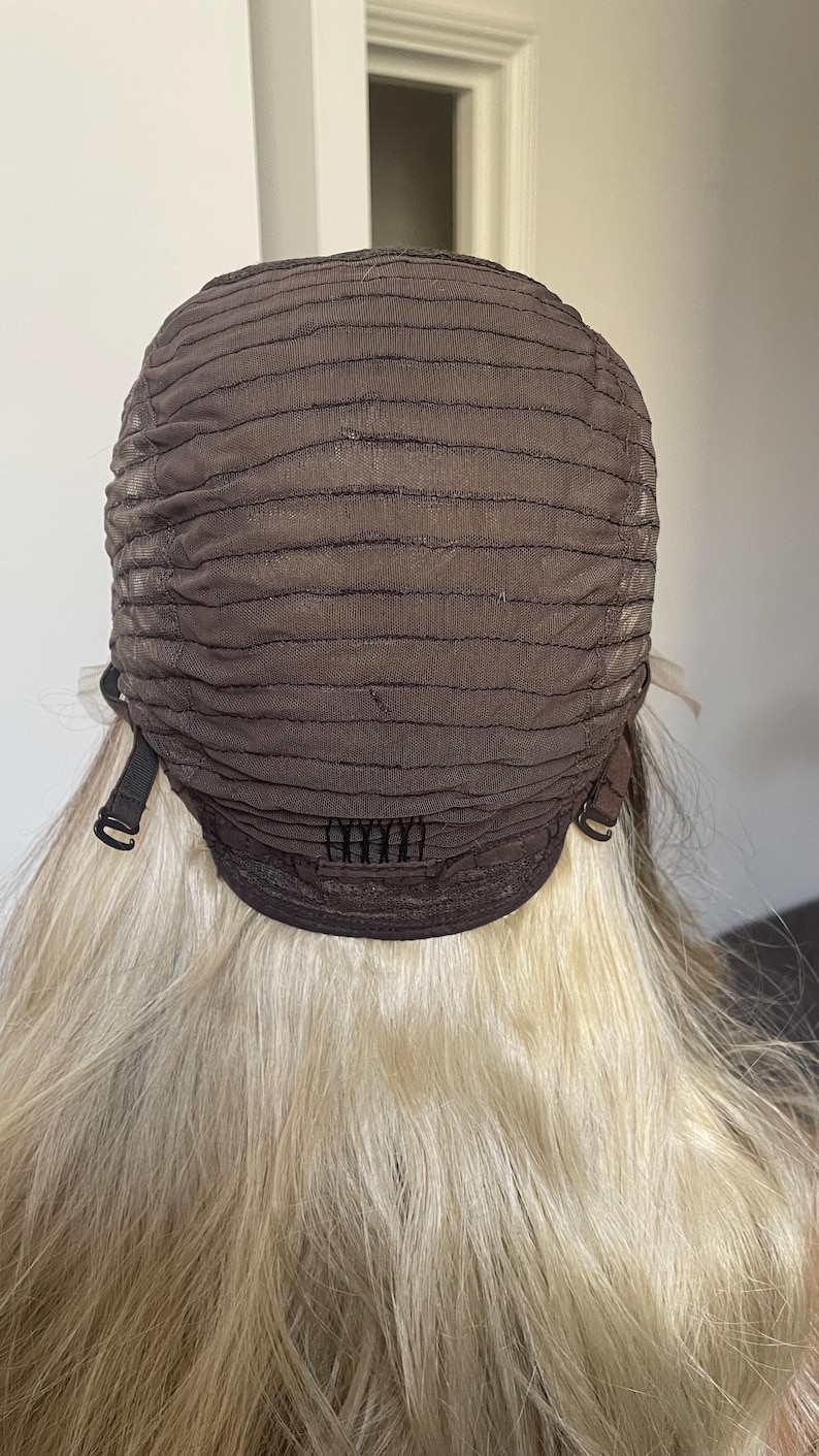 Puede incluir: Una gorra de peluca marr&oacute;n con correas y clips ajustables, sujeta a un cabello rubio largo y ondulado. El interior de la gorra presenta un dise&ntilde;o de malla. La peluca est&aacute; dise&ntilde;ada para ser usada en la cabeza.