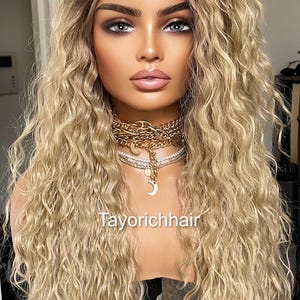 K&ouml;nnte beinhalten: Eine lange, blonde Per&uuml;cke mit lockeren, lockigen Wellen. Die Per&uuml;cke ist auf einem Mannequin-Kopf gestylt und hat einen nat&uuml;rlich aussehenden Haaransatz.