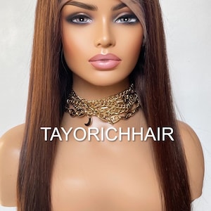 May include: A long, straight, brown human hair wig with a lace front. The wig is styled with a center part and falls to the shoulders. The wig is on a mannequin head with a gold chain necklace. The text "TAYORICHHAIR" is visible on the mannequin's chest.