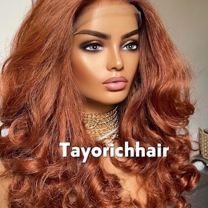 May include: A mannequin head with a copper-colored, wavy wig. The wig features long, voluminous curls and a lace front. The mannequin is wearing a gold chain necklace. The text "Tayorichhair" is displayed on the image.