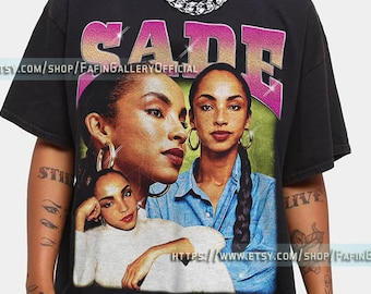 May include: Black t-shirt with a vintage-style graphic of Sade, a British singer-songwriter. The graphic features three images of Sade, with the text "SADE" in pink and purple letters above the images.