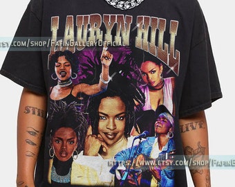 May include: Black t-shirt with a vintage-style graphic print of Lauryn Hill. The print features multiple images of Hill in different poses, with a gold and purple color scheme. The text "Lauryn Hill" is printed in large, bold letters across the top of the print.
