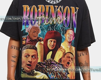 May include: Black t-shirt with a vintage-style graphic print of a group of people. The print features the text "Robinson" in a rainbow gradient with lightning bolts. The graphic is set against a dark blue background with stars.