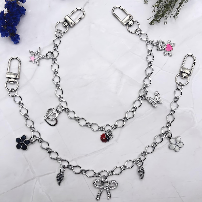 Silver aesthetic charm keychains with cute rhinestone bow, butterfly, teddy bear, and floral charms