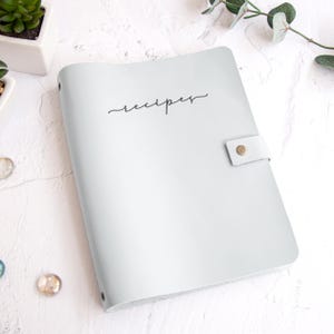 A white recipe book with the word "recipes" written on it