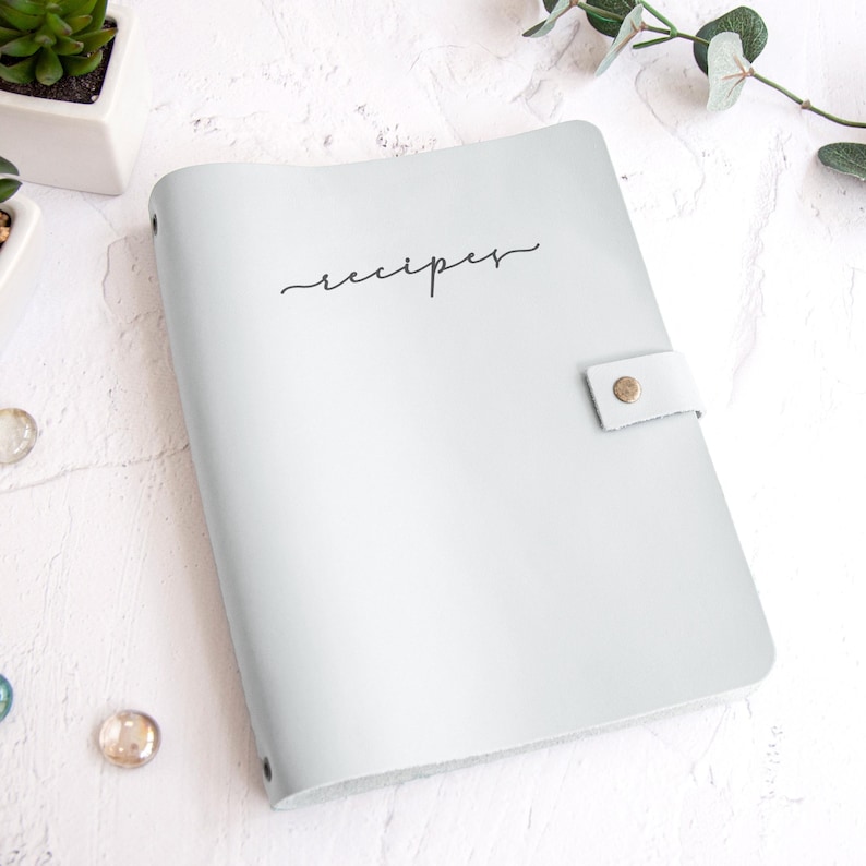 A white recipe book with the word "recipes" written on it