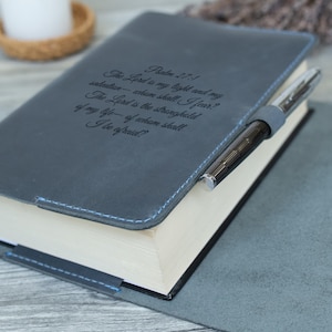 May include: A grey leather-bound journal with blue stitching detail and a silver pen. The cover features an engraved quote from Psalm 27:1, "The Lord is my light and my salvation - whom shall I fear? The Lord is the stronghold of my life - of whom shall I be afraid?"
