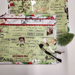 Könnte beinhalten: Eine grüne und weiße Reißverschlusstasche mit einem Vintage-Postkarten-Design. Die Tasche zeigt Bilder vom Weihnachtsmann, Stechpalme und die Worte "Post Card".