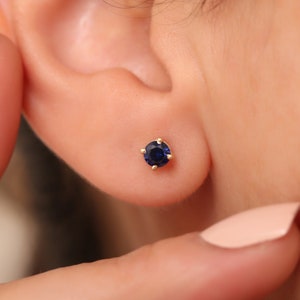 Pode incluir: Um par de brincos de ouro com uma única gema de safira azul em cada brinco.