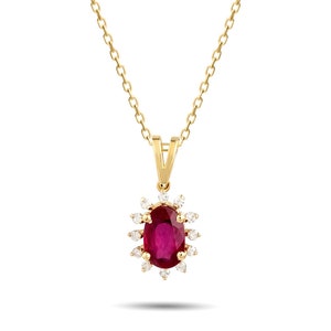 Op de afbeelding: Een gouden ketting met een hanger met een grote ovale robijn omringd door een halo van kleinere diamanten.