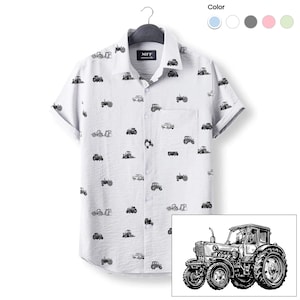 May include: A white short-sleeved button-down shirt with a black and white tractor print. The shirt has a small MFF Country Life logo on the left side of the chest. The shirt is shown on a hanger with a white background. The image also includes a close-up of a black and white tractor illustration.