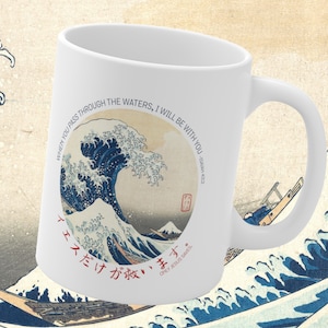 Könnte beinhalten: Weiße Keramiktasse mit einem blauen und weißen Bild der Großen Welle vor Kanagawa von Hokusai. Die Tasse trägt den Text "When you pass through the waters, I will be with you - Isaiah 43:2" und "イ ス だけ が 救 い ま す。 Only Jesus Saves" in Japanisch.