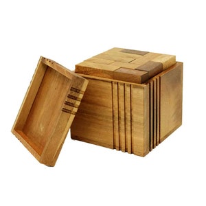 May include: A wooden puzzle box with a lid composed of rectangular pieces. The box is open, revealing a tray. The box and tray are made of light brown wood. The box has vertical grooves on the sides.