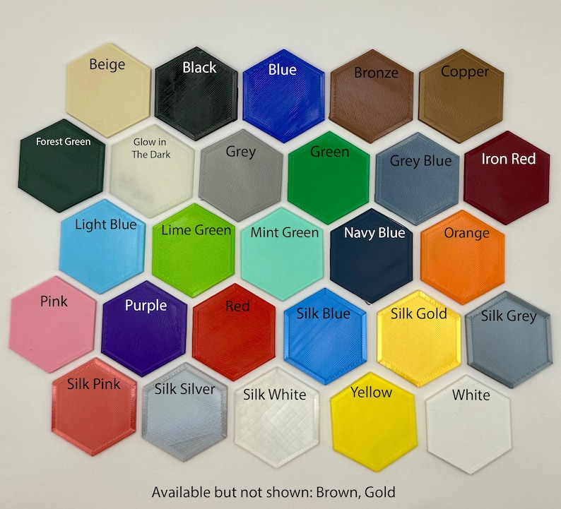 Puede incluir: Una carta de colores de 25 colores diferentes en forma de hex&aacute;gonos. Los colores incluyen beige, negro, azul, bronce, cobre, verde bosque, gris, verde, azul gris&aacute;ceo, rojo hierro, azul claro, verde lima, verde menta, azul marino, naranja, rosa, morado, rojo, azul seda, oro seda, gris seda, rosa seda, plata seda, blanco seda, amarillo y blanco. El texto "Disponible pero no mostrado: Marr&oacute;n, Oro" est&aacute; en la parte inferior de la carta.