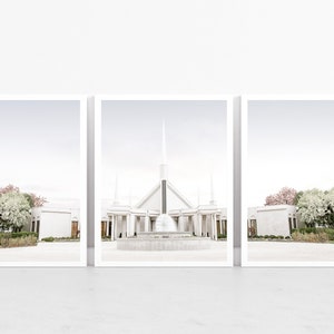 Puede incluir: Un edificio blanco con una alta aguja y una fuente en frente. El edificio está rodeado de árboles y arbustos. El cielo es de un azul claro.