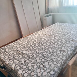 Peut inclure: Une nappe à motifs blancs et bruns avec un motif floral. La nappe est posée sur une table en bois.